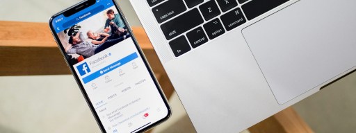 Facebook App Open in iPhone Next to a MacBook