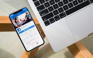Facebook App Open in iPhone Next to a MacBook