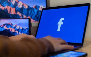 Person accessing Facebook on a Laptop.